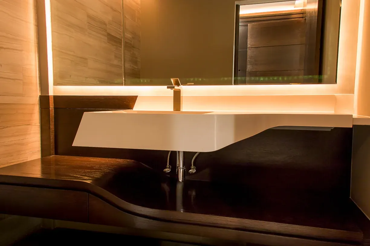 Lavabo suspendido bajo el espejo retroiluminado