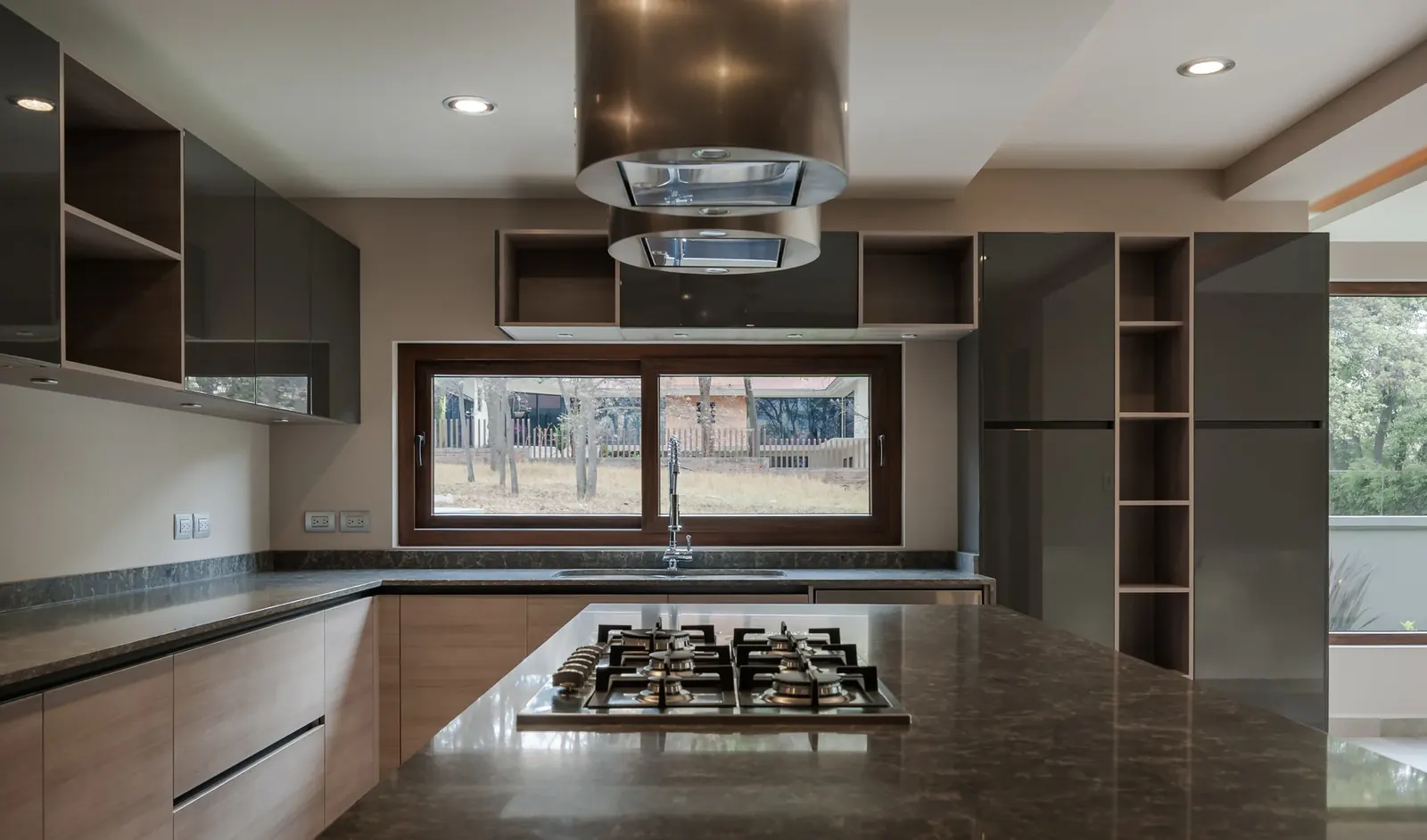 Cocina con alacenas oscuras y ventana sobre la cubierta de trabajo