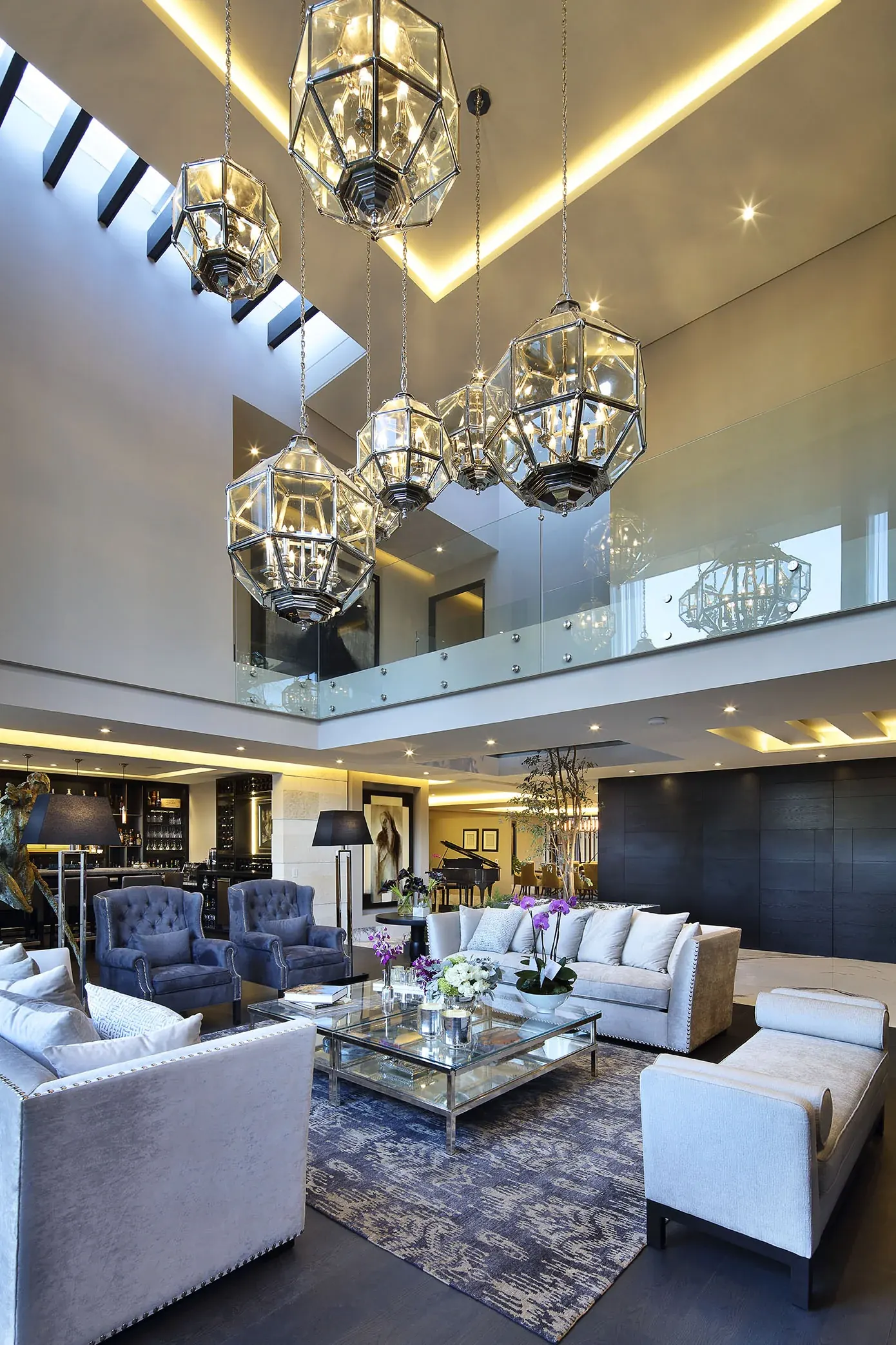 Sala de doble altura, con dos lámparas esféricas sobre la estancia