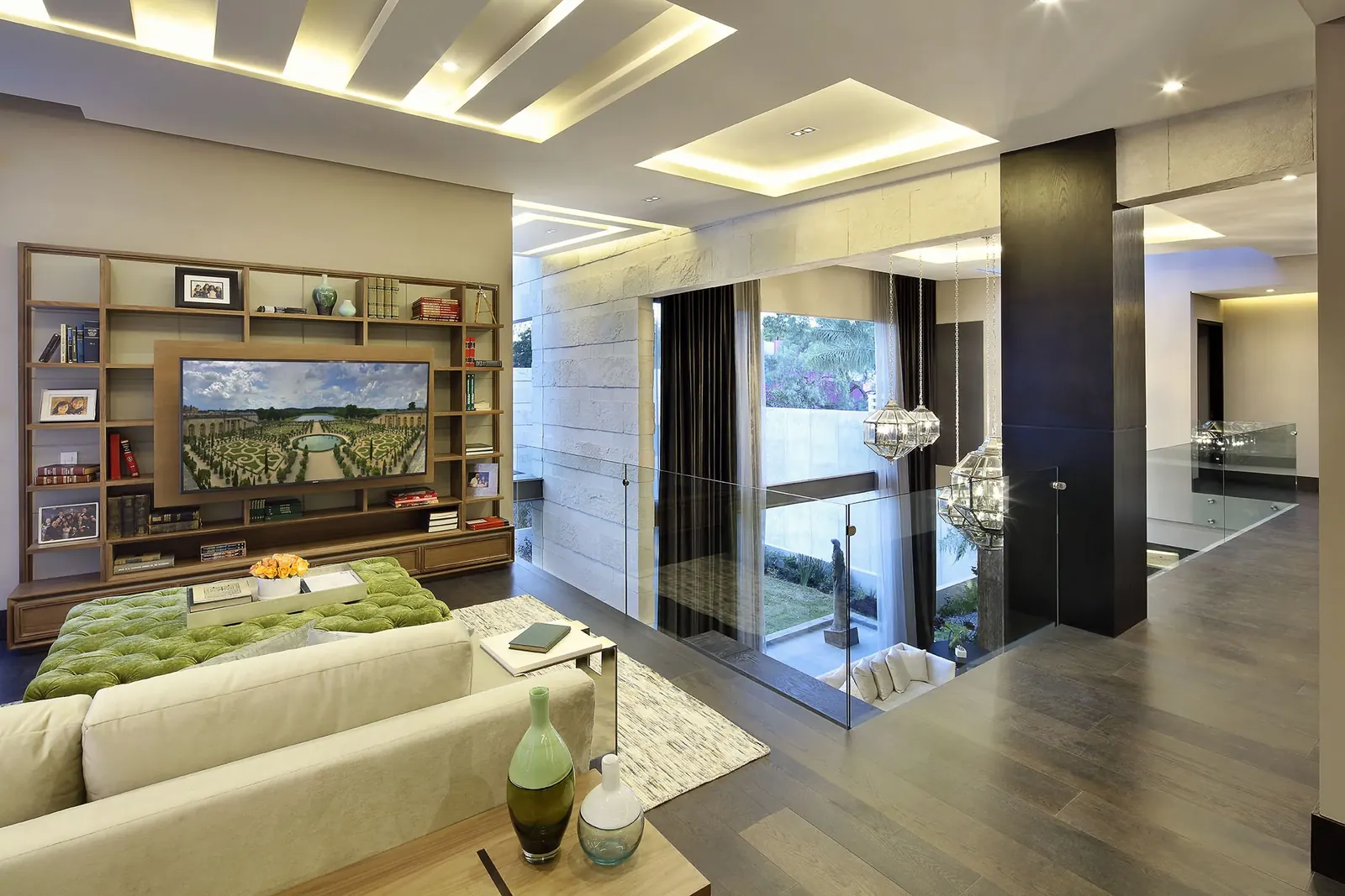 Sala de estar con librero, y el jardín detrás de la puerta corrediza