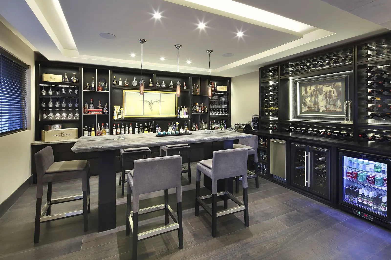 Bar con banquetas altas y la cava de vino al fondo