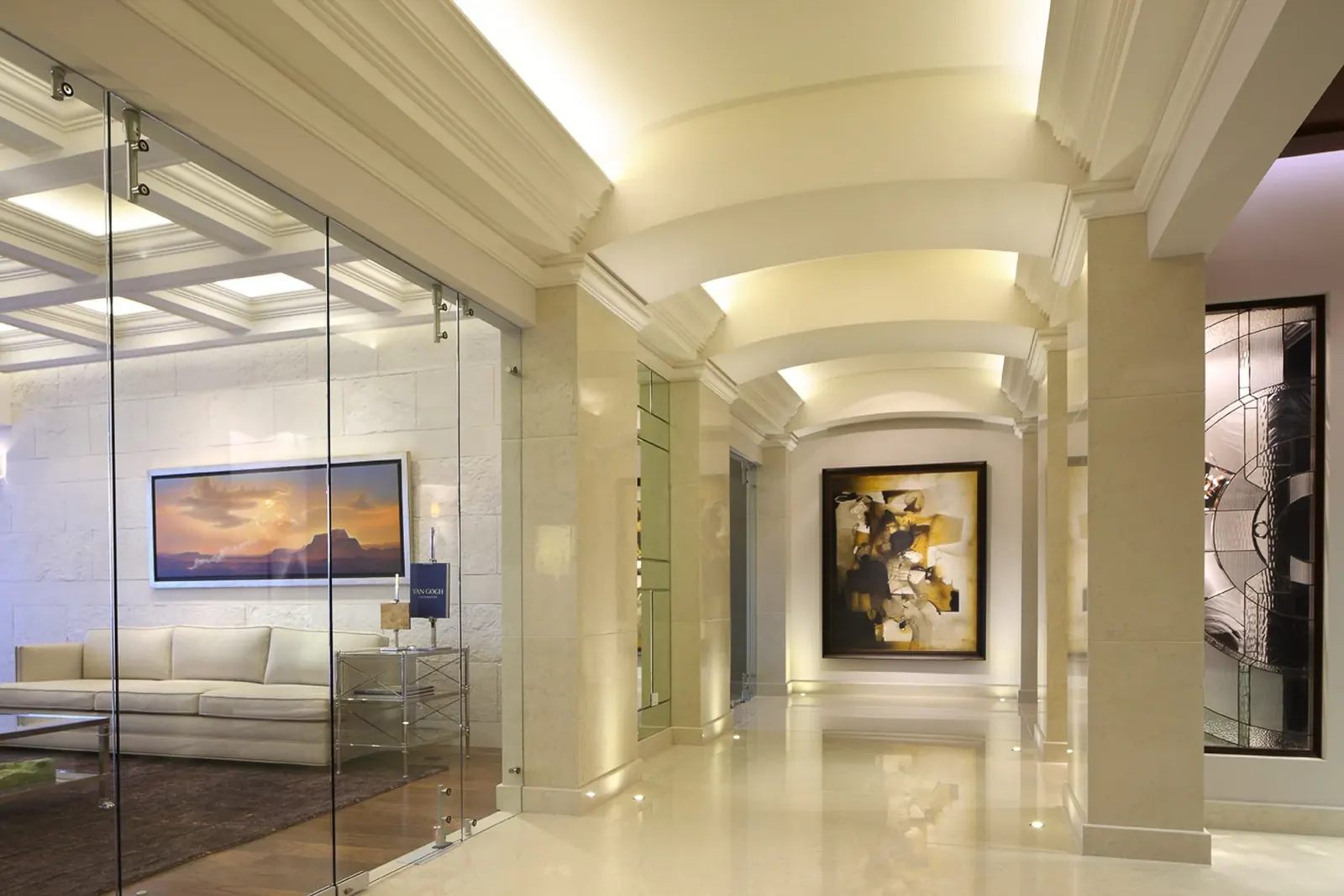 Galería de acceso, entre muros de cristal y columnas de piedra