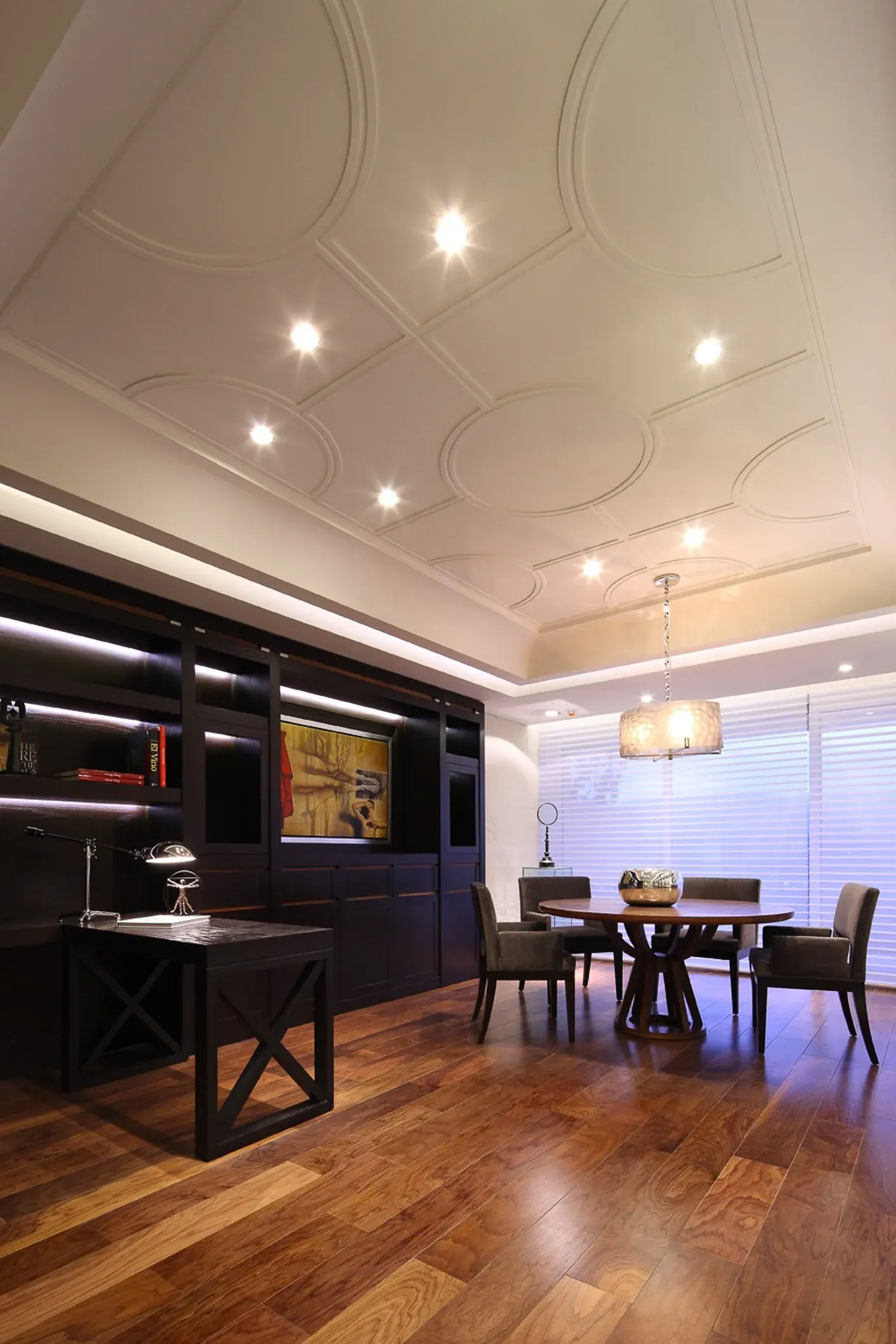 Comedor con muros de madera oscura y lámpara sobre la mesa redonda