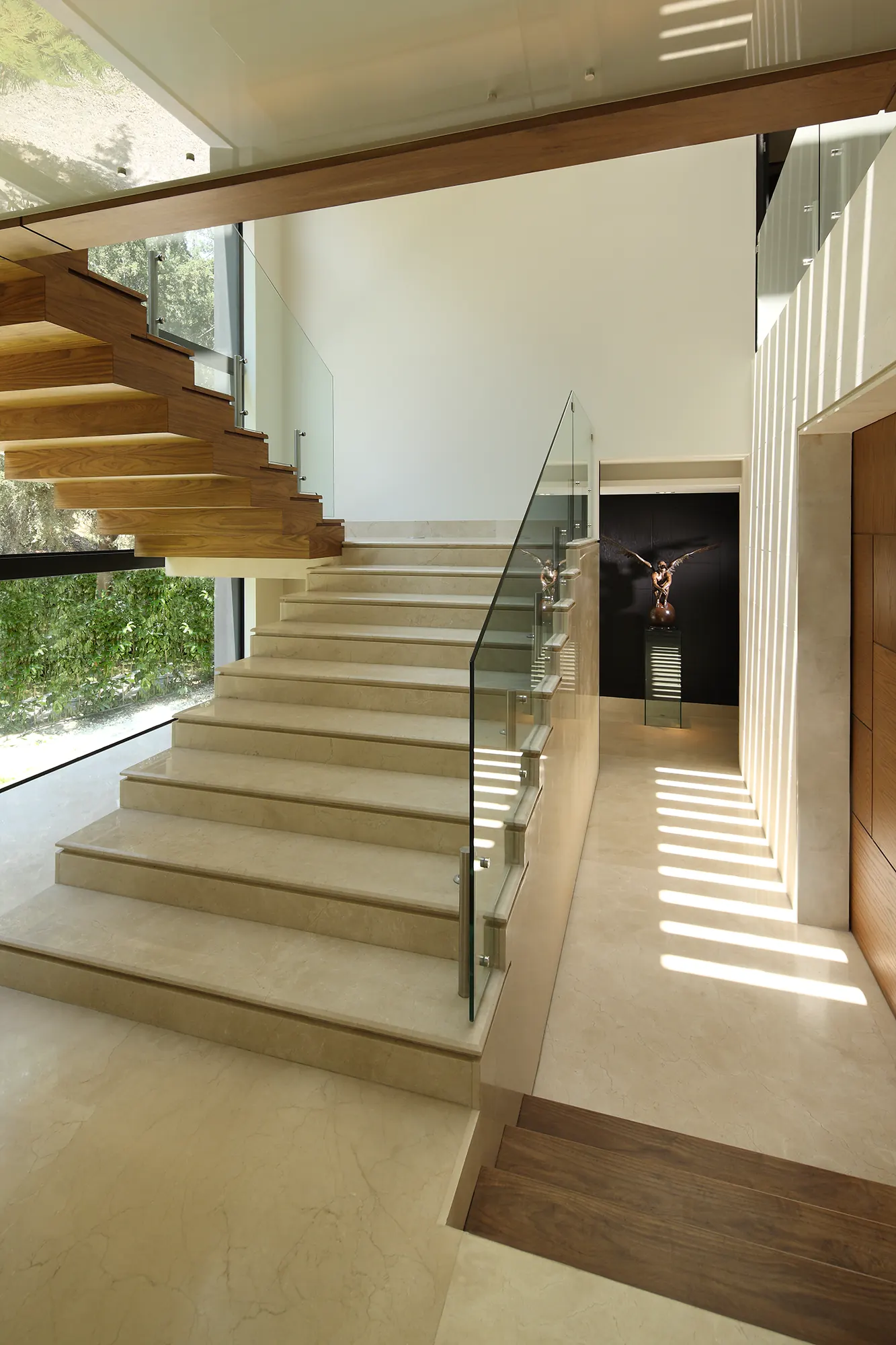 Escalera de peldaños de madera, bañada por la luz del ventanal