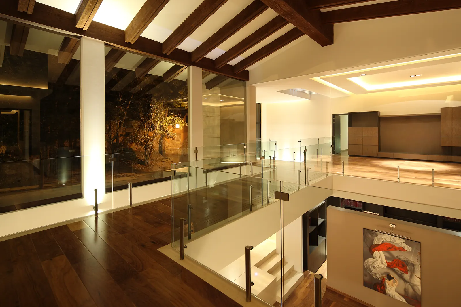 Estancia con vigas de madera, abierta al vestíbulo de doble altura
