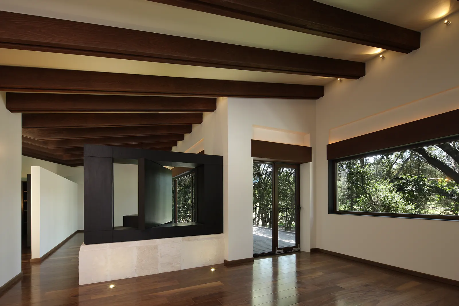 Sala con vigas oscuras y el volumen de la chimenea