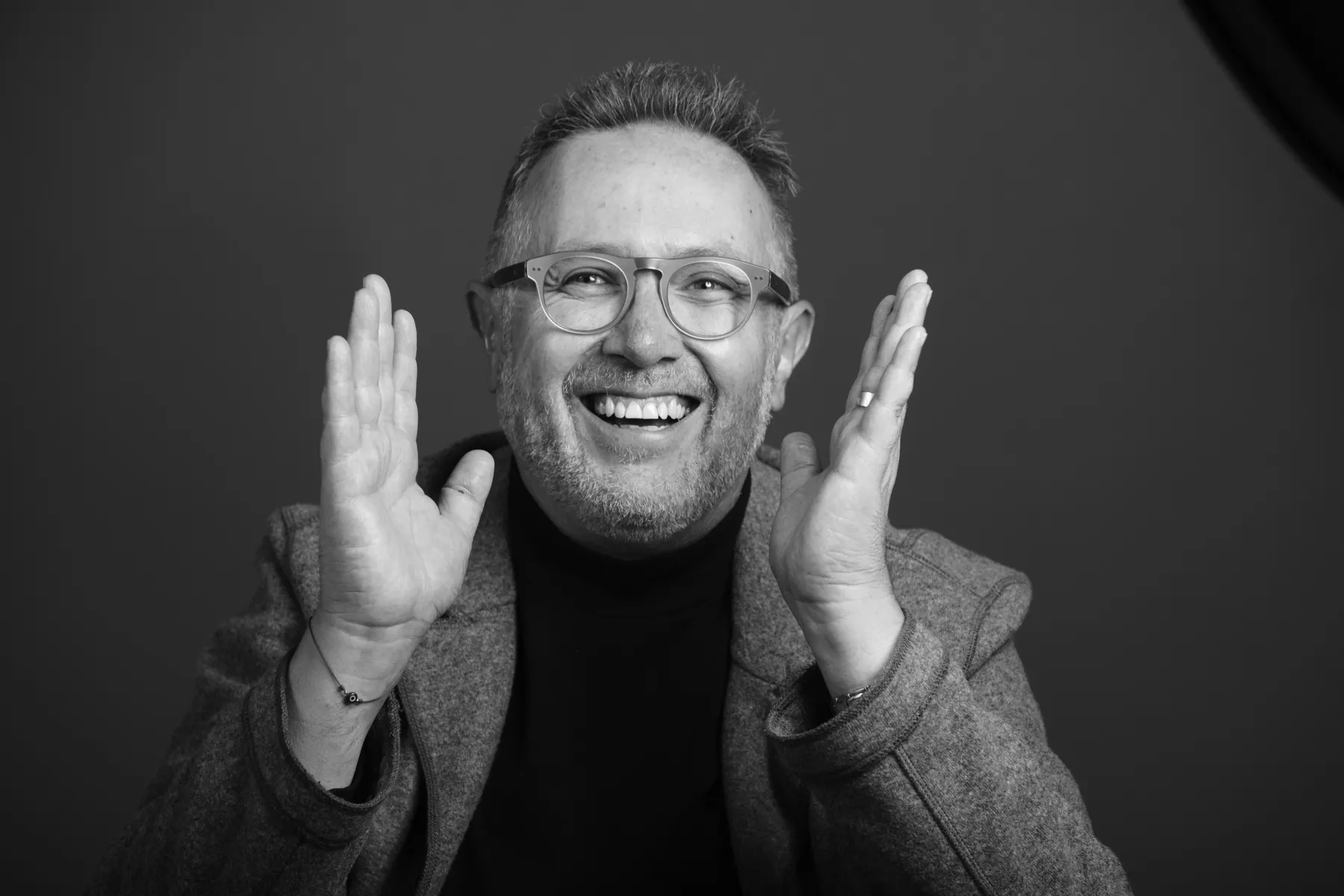 Jaime Lavín riendo, con las manos abiertas, en un retrato en blanco y negro
