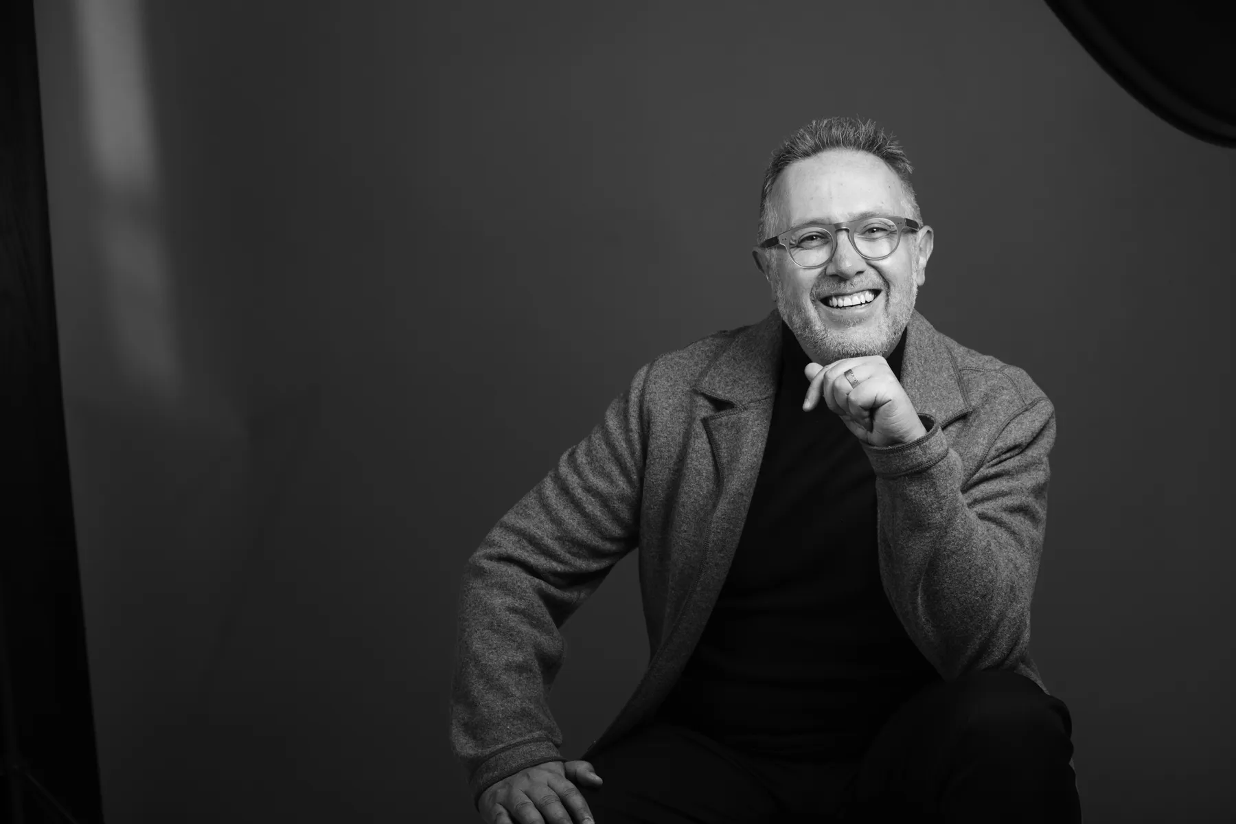 Jaime Lavín sentado, sonriendo, en un retrato en blanco y negro